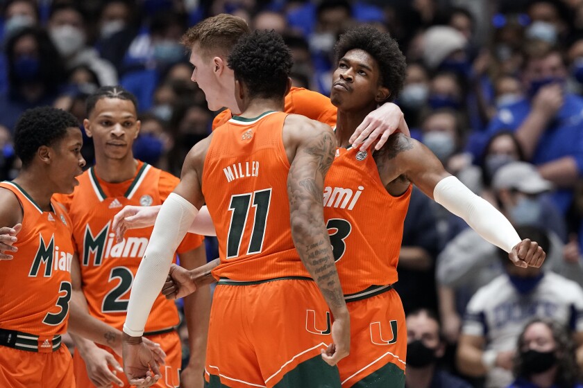 Miami guards Jordan Miller (11) and Kameron McGusty celebrate with Charlie Moore (3), Isaiah Wong (2) and forward Sam Waardenburg during the second half of the team's NCAA college basketball game against Duke in Durham, N.C., Saturday, Jan. 8, 2022. (AP Photo/Gerry Broome)