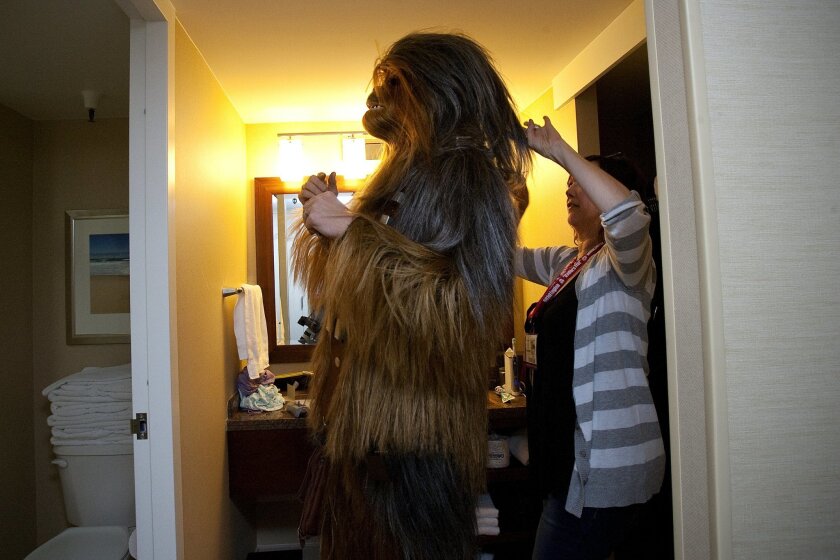 On Friday, "Star Wars" enthusiast Ben Townend gets into his handmade Chewbacca costume with the help of his wife.