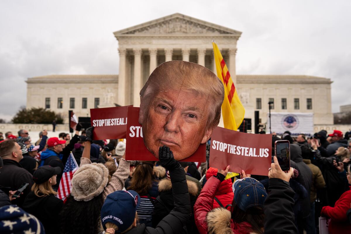 People listen to speakers during a "Stop the Steal" rally in front of the Supreme Court 