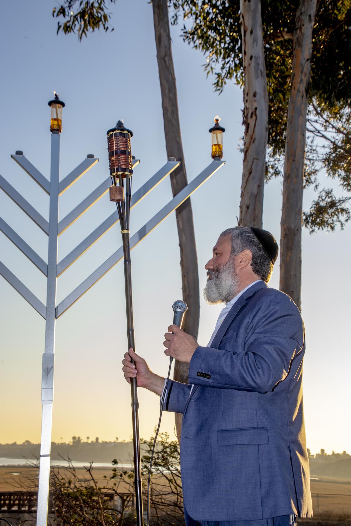 Rabbi Reuben Mintz completes the lighting of the menorah.