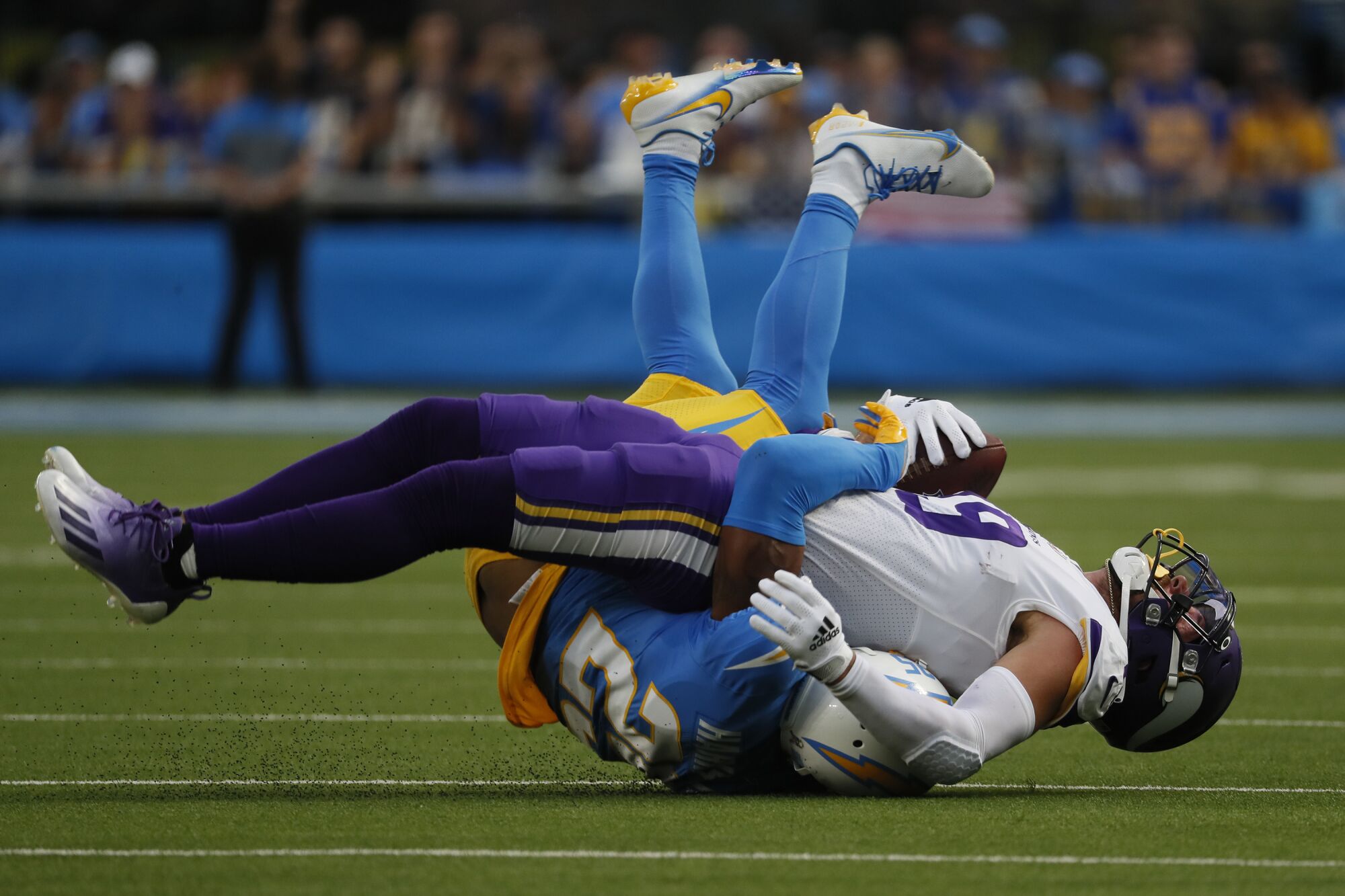 Minnesota Vikings wide receiver Adam Thielen is tackled by Chargers cornerback Chris Harris in the first half.