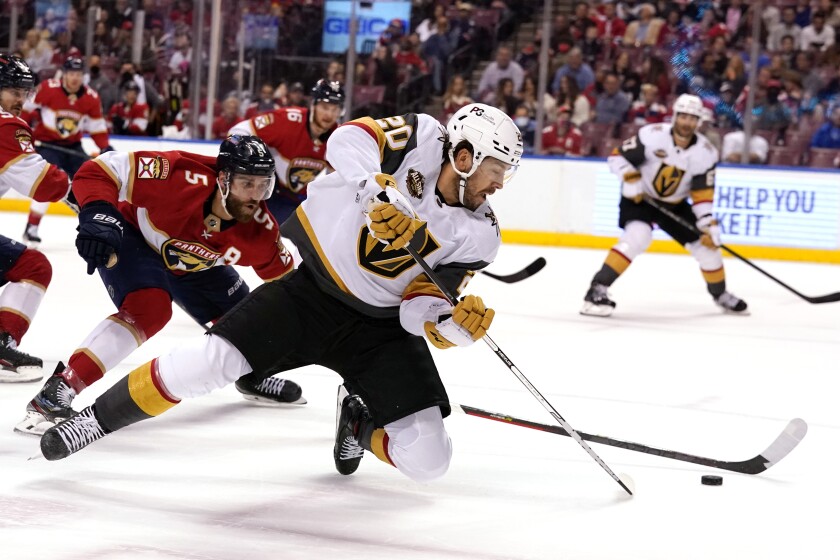 Florida Panthers defenseman Aaron Ekblad (5) and Vegas Golden Knights center Chandler Stephenson (20) go for the puck during the first period of an NHL hockey game, Thursday, Jan. 27, 2022, in Sunrise, Fla. (AP Photo/Lynne Sladky)