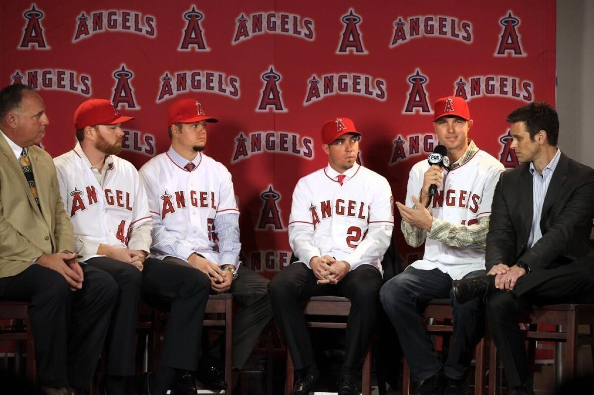 Angels Manager Mike Scioscia sits next to, left to right, right-handed pitcher Tommy Hanson, right-handed pitcher Joe Blanton, left-handed pitcher Sean Burnett, right-handed pitcher Ryan Madson and the general manager of the team Jerry Dipoto.