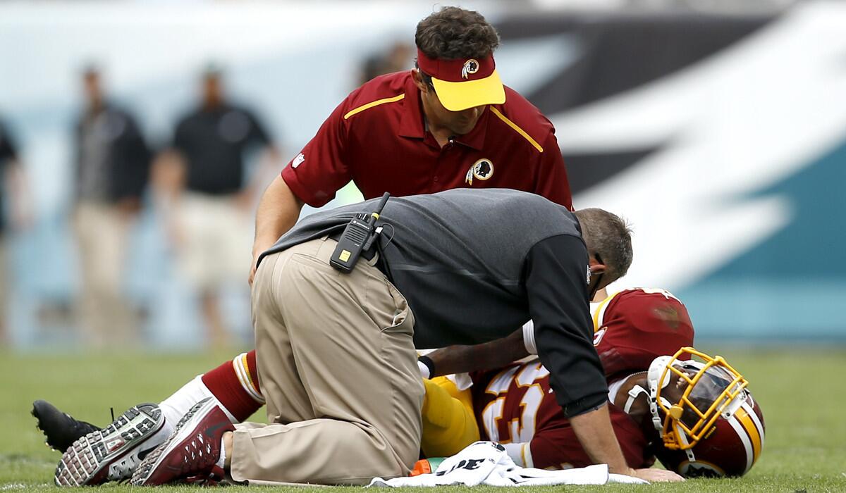 Redskins cornerback DeAngelo Hall is tended to by trainers after injuring his Achilles tendon in the second half of a game against the Eagles on Sunday in Philadelphia.