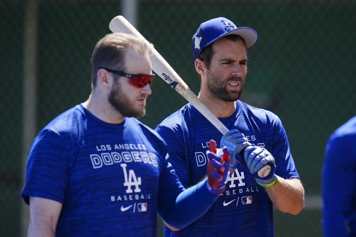 Dodgers teammates Max Muncy and Chris Taylor take part in batting practice.