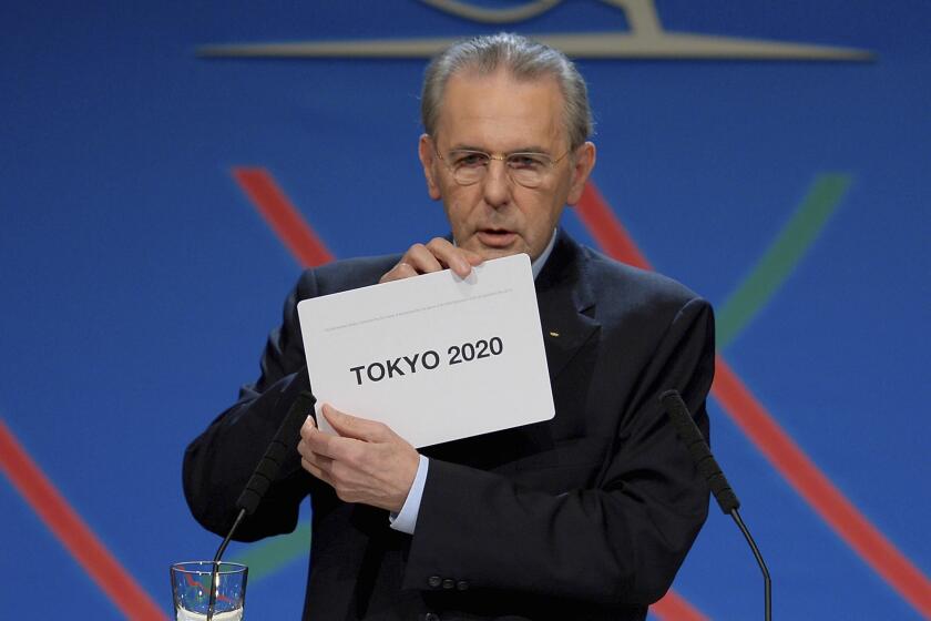 FILE - In this Saturday, Sept. 7, 2013 file photo, International Olympic Committee (IOC) President Jacques Rogge shows the name of the city of Tokyo elected to host the 2020 Summer Olympics in Buenos Aires, Argentina. The International Olympic Committee on Sunday, Aug, 29, 2021 says Jacques Rogge who led the organization as president for 12 years, has died. He was 79. (Fabrice Coffrini/Pool photo via AP, file)