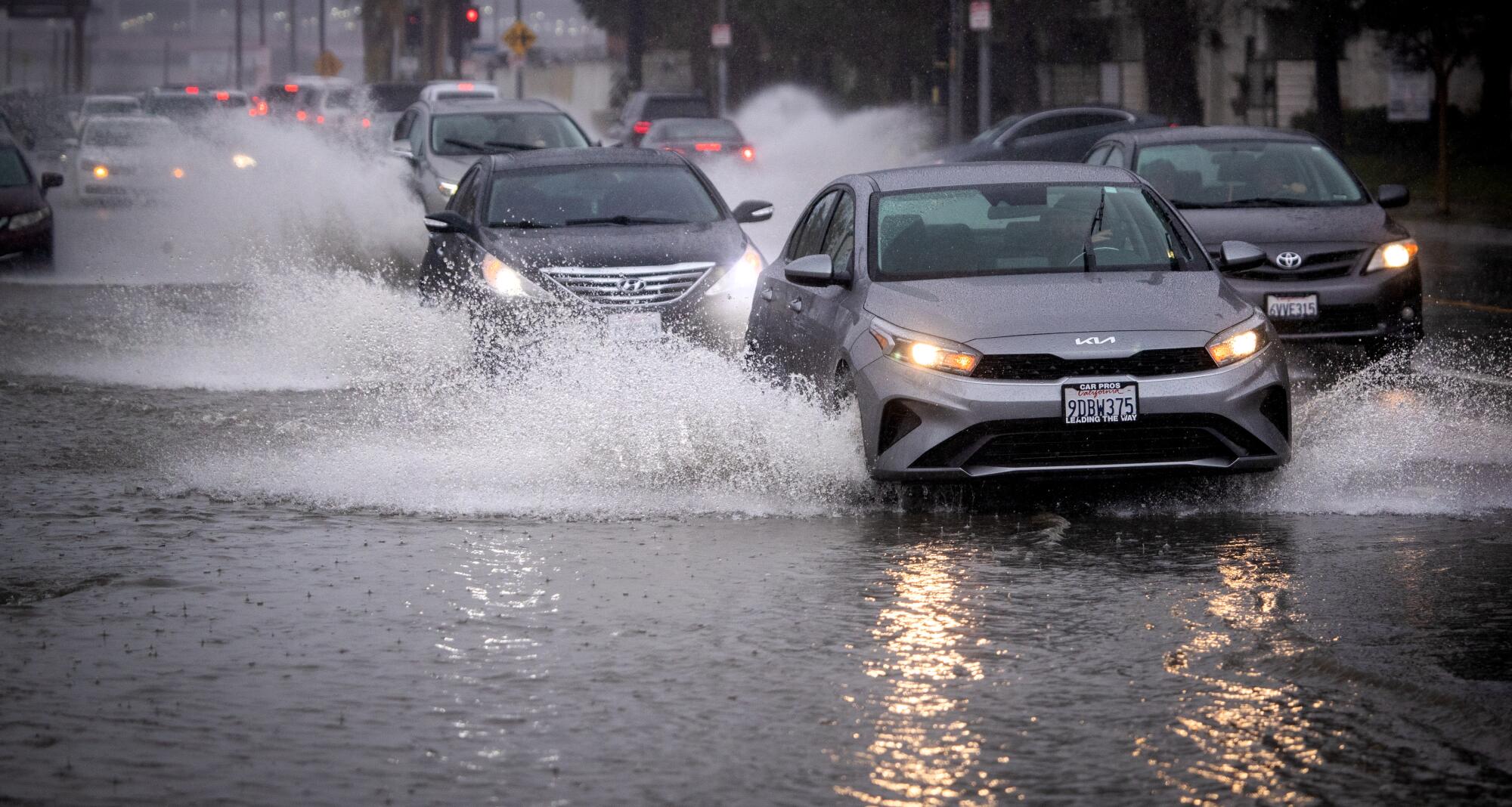 Motorists drive through a flooded area of Vanowen Street in North Hollywood amid heavy rain Friday.