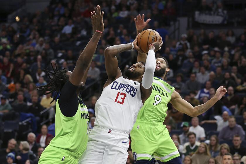 Los Angeles Clippers Paul George (13) tries to shoot against Minnesota Timberwolves' Naz Reid in the second half of an NBA basketball game Saturday, Feb. 8, 2020, in Minneapolis. (AP Photo/Stacy Bengs)