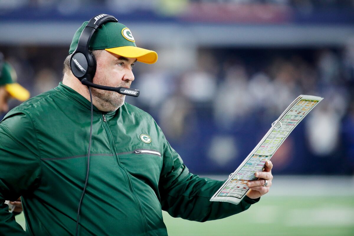 Mike McCarthy stands on the sideline.