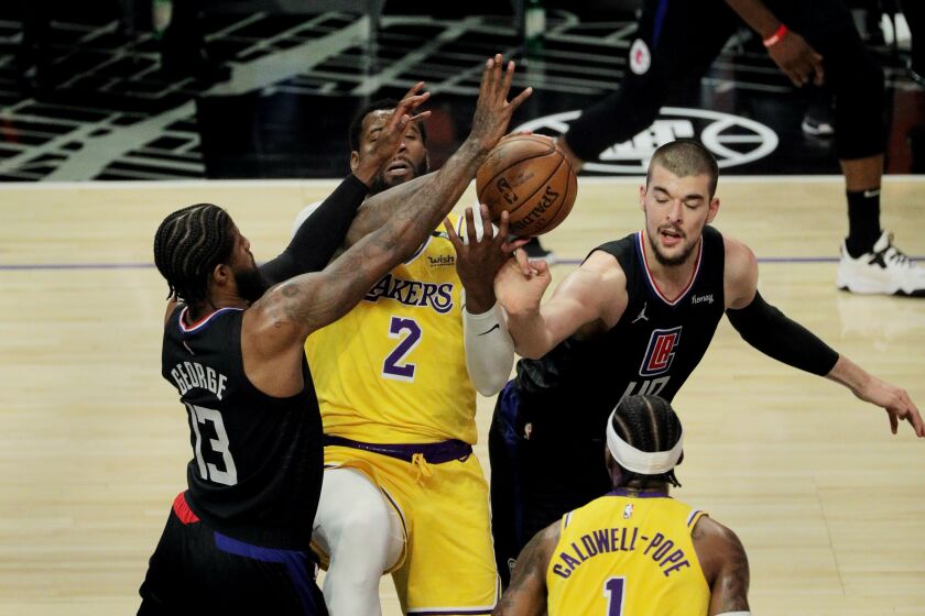 LOS ANGELES, CA - MAY 6, 2021: Los Angeles Lakers center Andre Drummond (2) can't grab a defensive rebound while being double teamed by LA Clippers guard Paul George (13) and LA Clippers center Ivica Zubac (40) in the first half at Staples Center on May 6, 2021 in Los Angeles, California.(Gina Ferazzi / Los Angeles Times)
