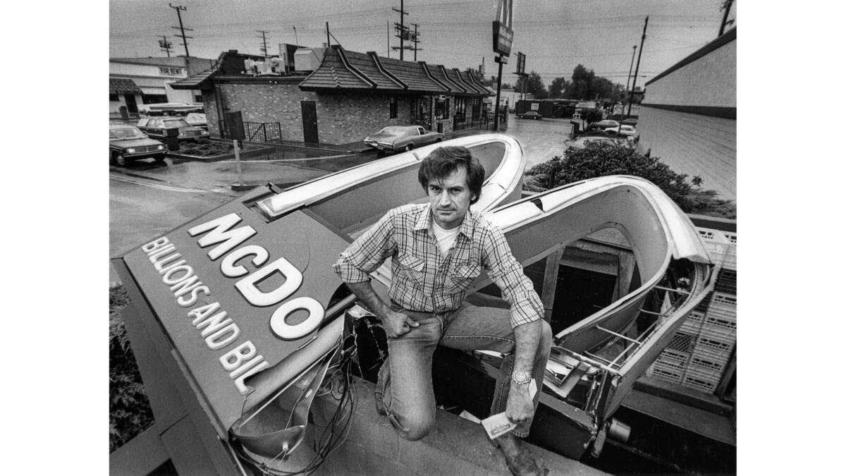 Sep. 12, 1984: Daniel Chadwick stands atop McDonald's sign he toppled in North Hollywood. The site was involved in a legal dispute.