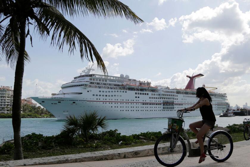 In this Monday, May 19, 2014 photo, the Carnival Cruise Lines ship Ecstasy leaves the Port of Miami as it passes Miami Beach, Fla. (AP Photo/Lynne Sladky) ORG XMIT: OTK