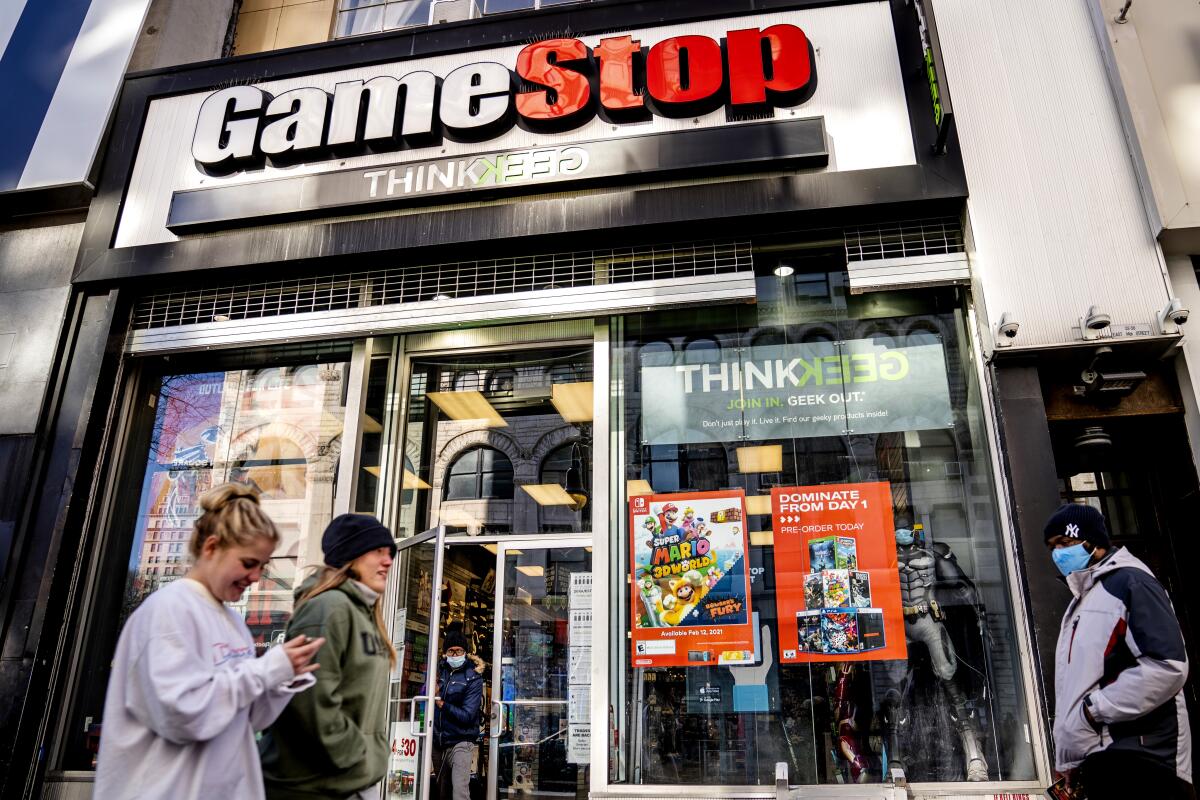 People walk past a GameStop store in New York.
