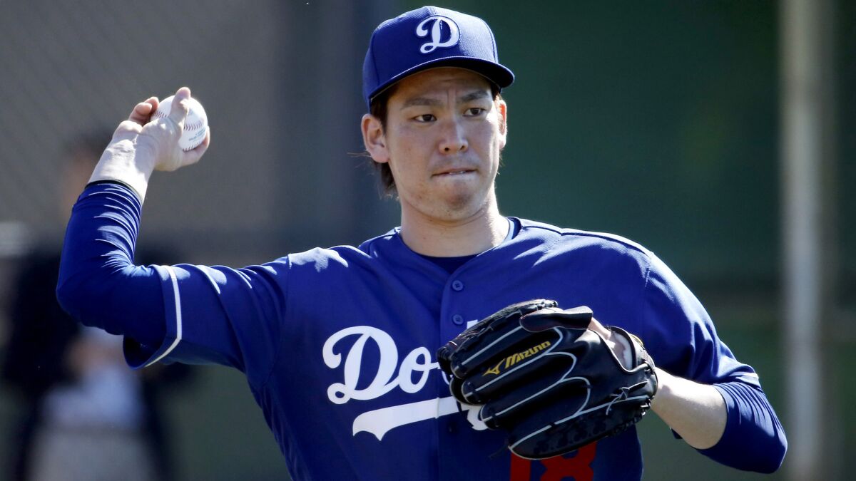Dodgers rookie Kenta Maeda throws during a spring training baseball workout Feb. 20.