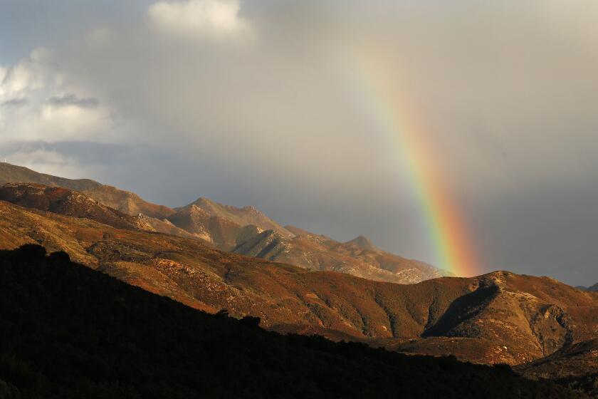 Saturday afternoon rain from the first of several wet storm systems approaching California in the coming week creates a rainbow over the Santa Ynez Mountains on the Gaviota Coast of Santa Barbara County with Condor Point in the background at an elevation of 3001 feet.