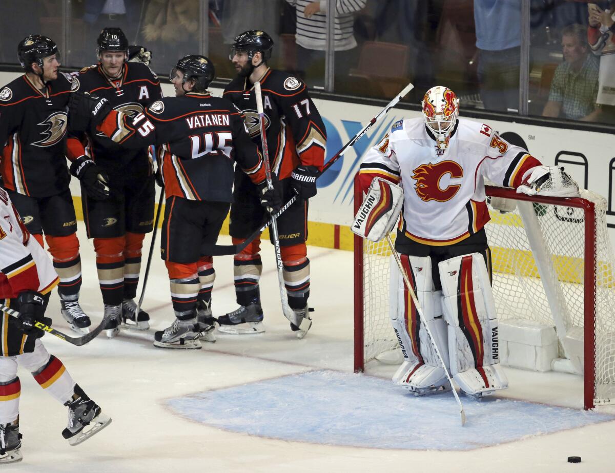 Ducks celebrate a goal by center Ryan Kessler (17), rear, as Calgary Flames goalie Chad Johnson (31) stands at the goal in the third period on Nov. 6.