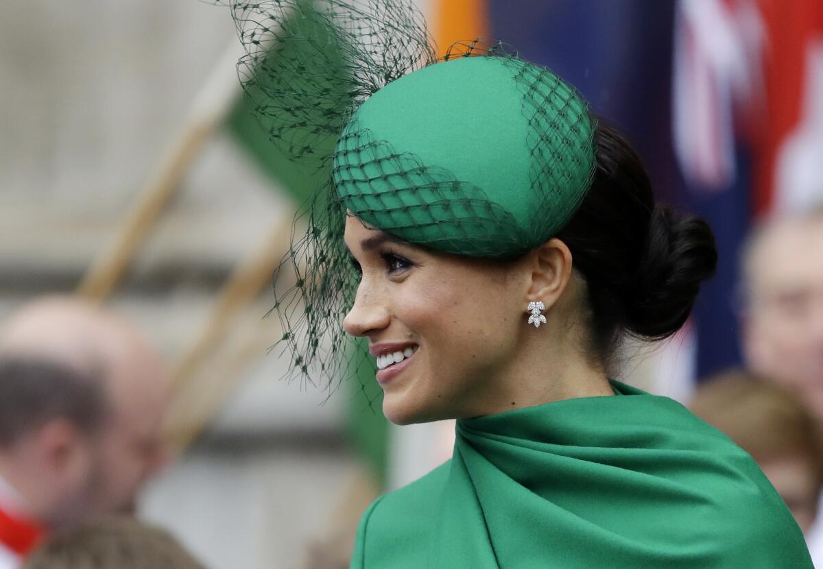 Meghan Markle wearing a green hat and dress