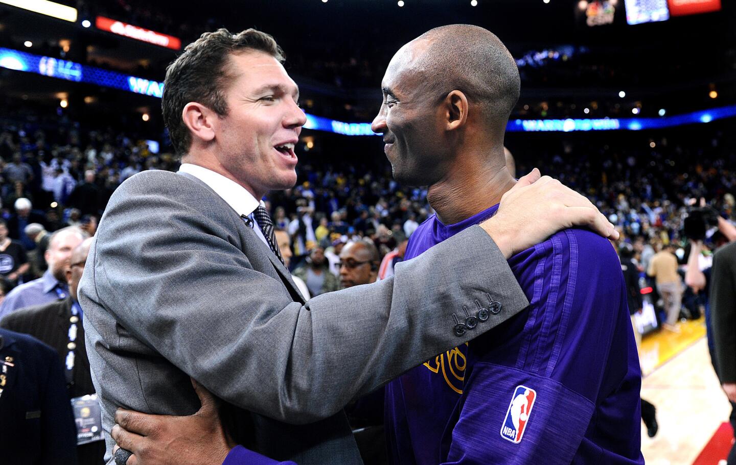 Kobe Bryant hugs former Lakers teammateand current Warriors assistant coach Luke Walton after a game in Oakland on Jan. 14, 2016.