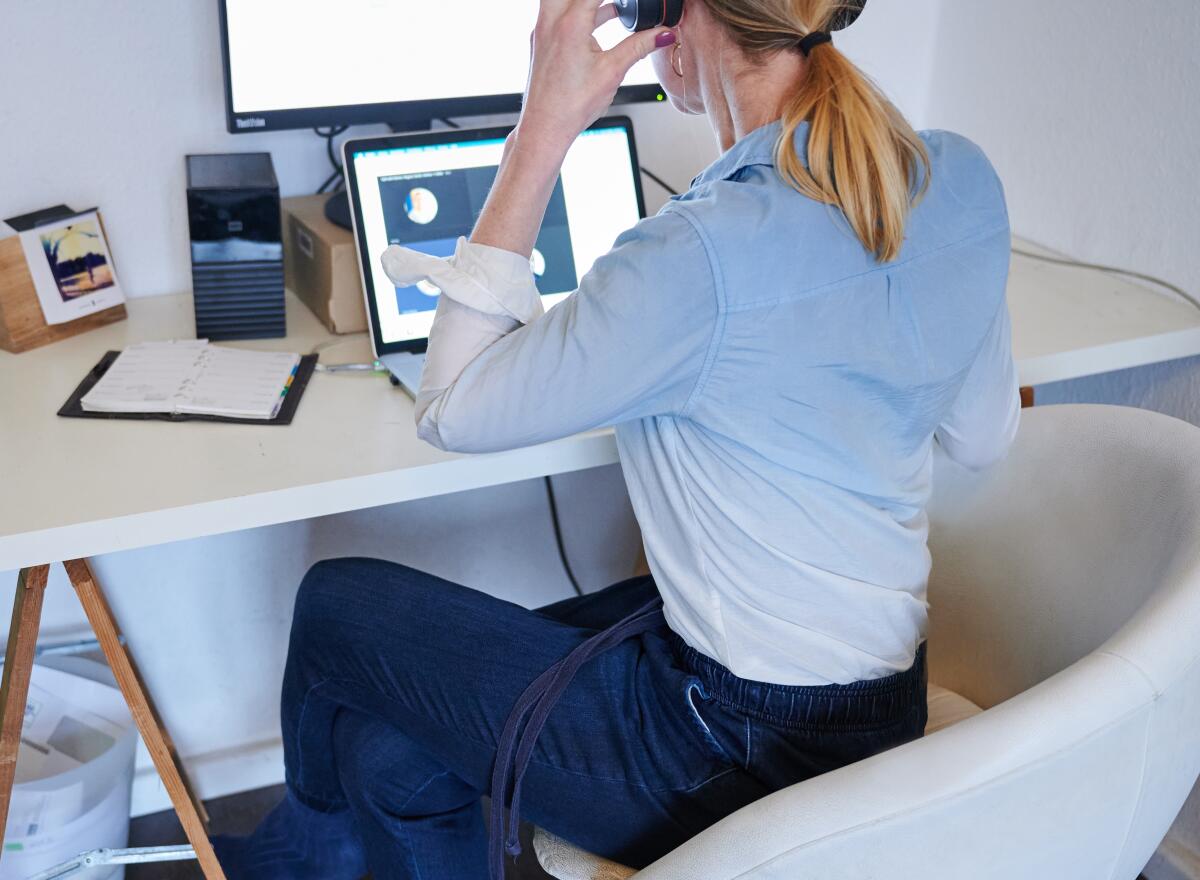 A woman attends an online meeting while working from home.