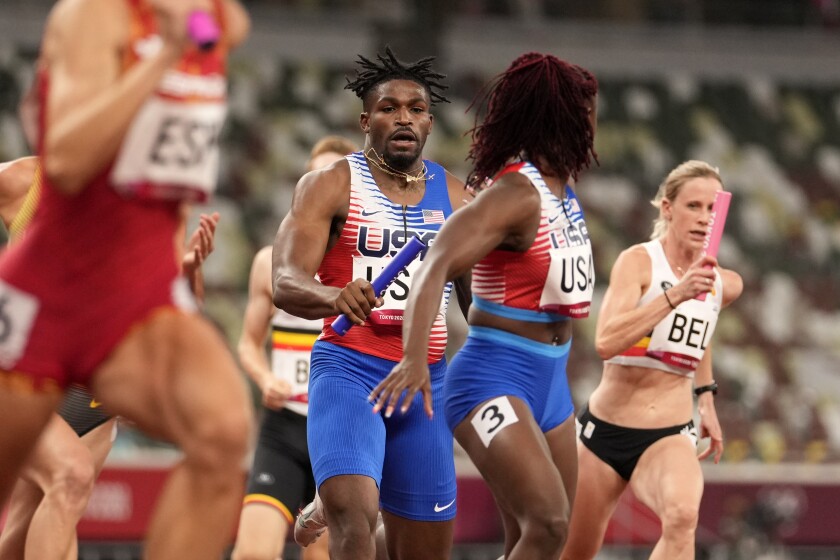 Elija Godwin hands the baton to U.S. teammate Lynna Irby during a 1,600-meter mixed relay.