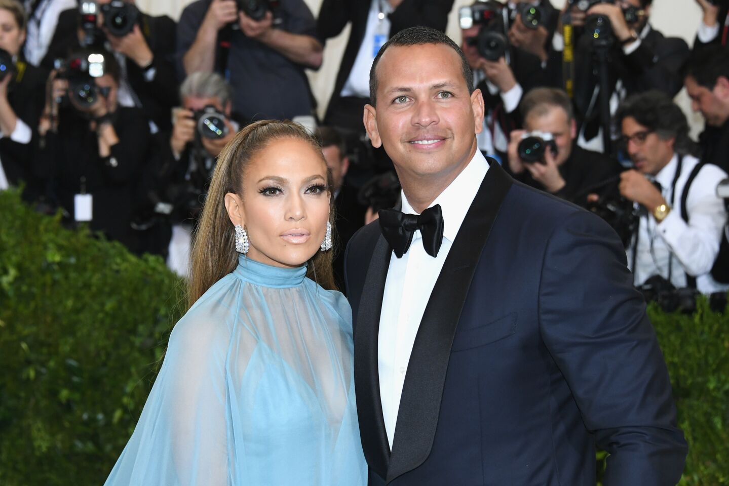 Jennifer Lopez and Alex Rodriguez take photos on the red carpet at the Met Gala.