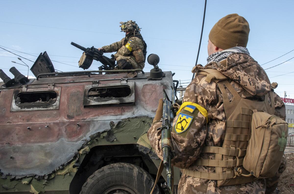 Soldados ucranianos inspeccionan un vehículo militar dañado tras combates en Járkiv, Ucrania.