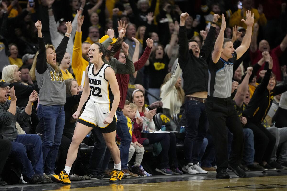 Iowa star Caitlin Clark celebrates after breaking the NCAA women all-time scoring record against Michigan.