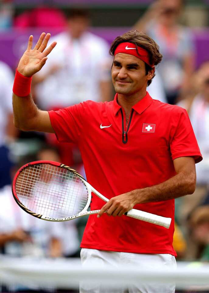 Roger Federer of Switzerland waves to the crowd after his win over Denis Istomin of Uzbekistan in the third round of Olympic tennis at Wimbledon. The Olympic tennis players are the first in the venue's long history to be allowed to wear bright colors on Wimbledon courts.