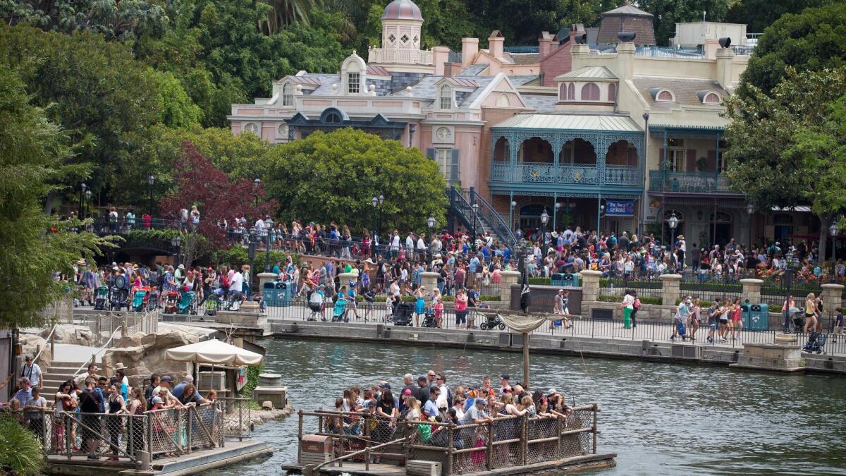 Crowds fill rafts to Tom Sawyer Island with New Orleans Square in the background in this 2015 photo.