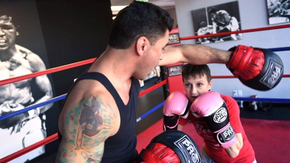 Jill Weiss, right, trains with former boxing champion Ricky Quiles at Ricky's Boxing Gym.