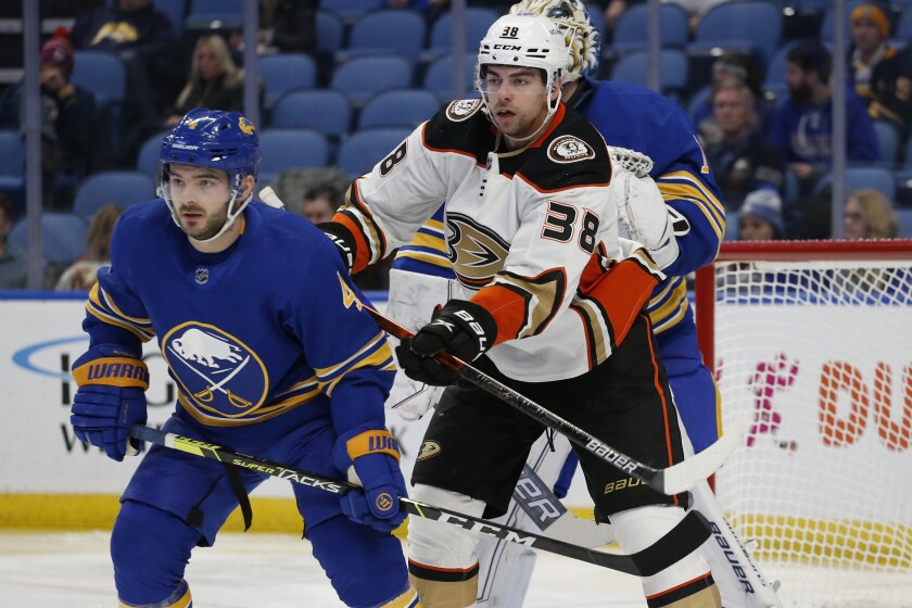 Buffalo Sabres defenseman Will Butcher and Ducks center Derek Grant battle for position.