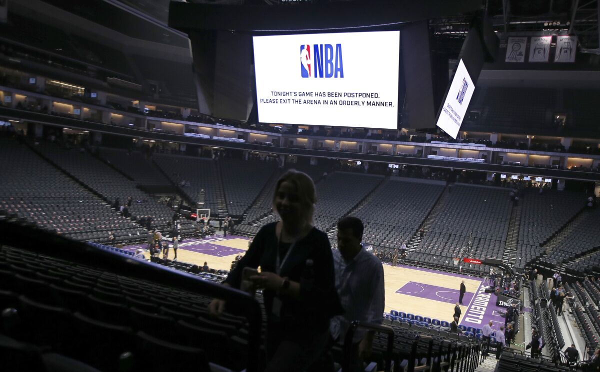 FILE - Fans leave the Golden 1 Center after the NBA basketball game between the New Orleans Pelicans and Sacramento Kings was postponed at the last minute in Sacramento, Calif., March 11, 2020. The NBA suspended the season "until further notice" after Rudy Goebert of the Utah Jazz tests positive for the coronavirus. (AP Photo/Rich Pedroncelli, File)