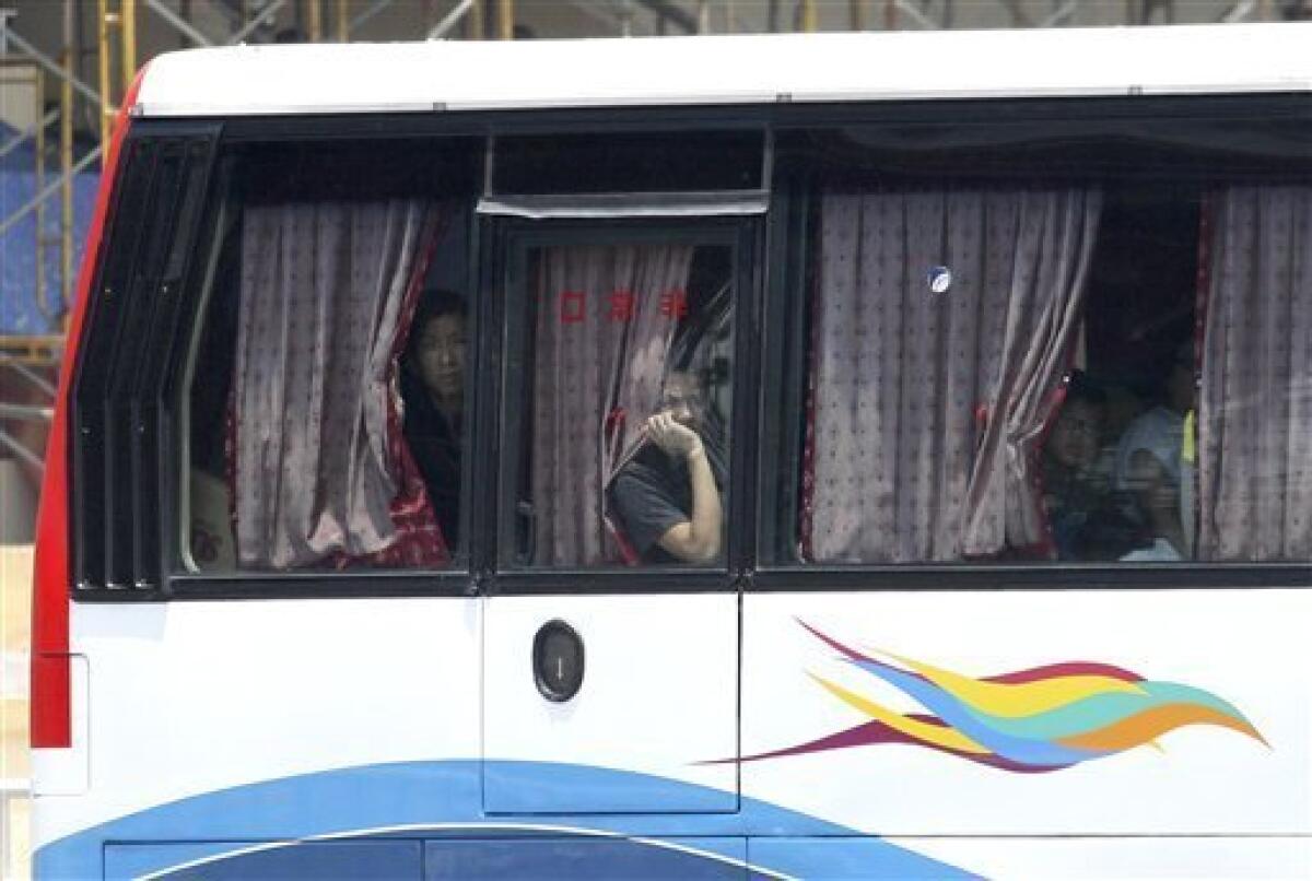 Hostages peer from the window of a tourist bus during a standoff at Rizal Park Monday Aug. 23, 2010 in Manila, Philippines. Former Police Senior Inspector Rolando Mendoza, a dismissed policeman armed with automatic rifle, seized the bus in Manila Monday with 25 people aboard, mostly foreign tourists in a bid to demand reinstatement, police said. (AP Photo/Bullit Marquez)