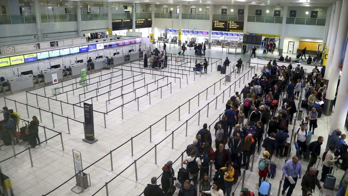 Passengers queue up at Gatwick Airport as airlines work to clear the backlog of flights delayed by the drone incident.