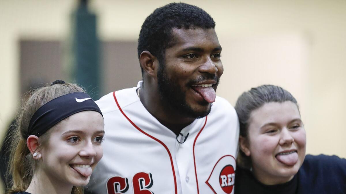 Cincinnati Reds right fielder Yasiel Puig poses for a photograph with young athletes at the Reds Youth Academy on Jan. 30.