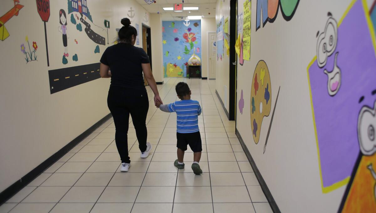 A migrant child and a caregiver at a 'tender age' facility