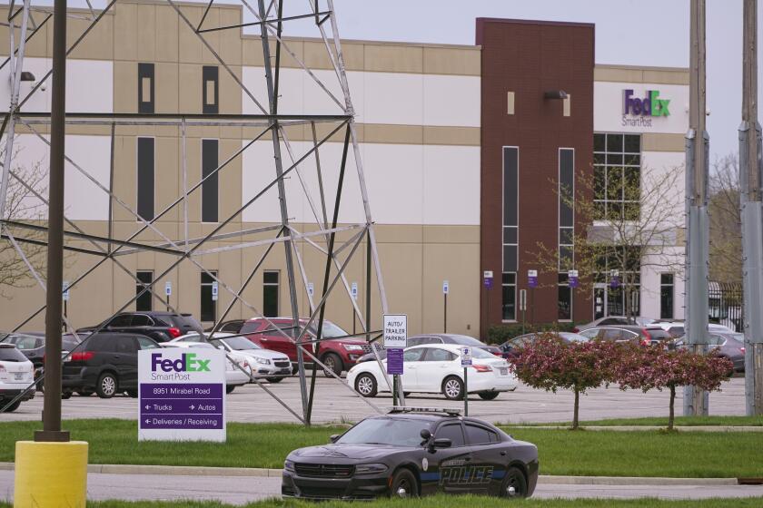 A sheriff's car blocks the entrance to the FedEx facility in Indianapolis, Saturday, April 17, 2021 where eight people were killed during a shooting late Thursday night. (AP Photo/Michael Conroy)