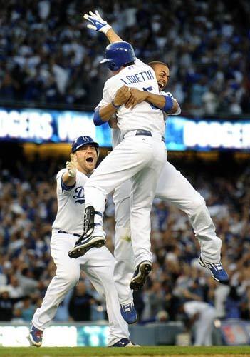 Dodgers pinch-hitter Mark Loretta jumps into the arms of center fielder Matt Kemp as catcher Russell Martin arrives to celebrate Loretta's game-winning hit against the Cardinals in Game 2 on Thursday.