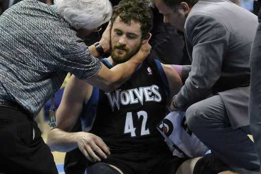 Minnesota Timberwolves forward Kevin Love is examined by a doctor after he took an elbow to the head.