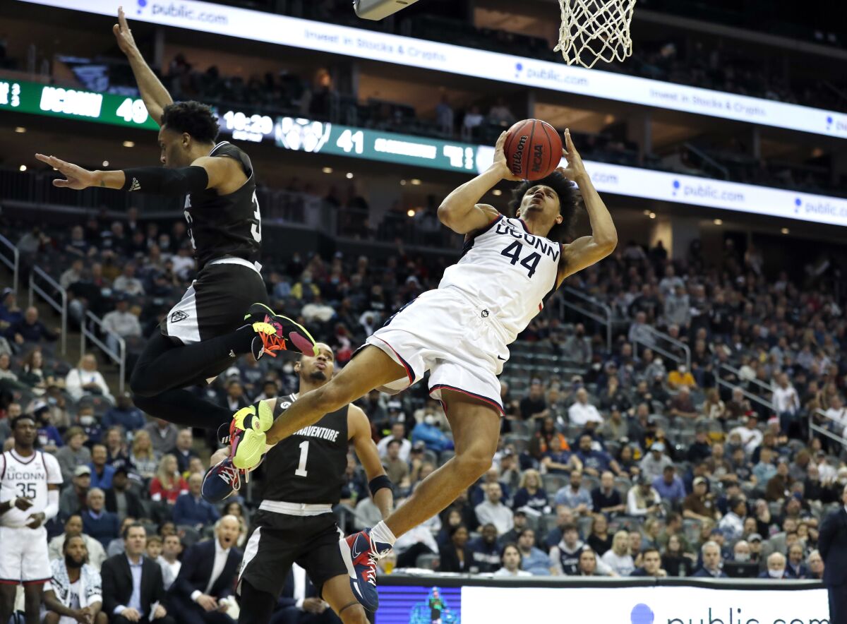Connecticut guard Andre Jackson (44) drives to the basket against St. Bonaventure guard Jalen Adaway (33) during the second half of an NCAA college basketball game in Newark, N.J., Saturday, Dec. 11, 2021. (AP Photo/Noah K. Murray)