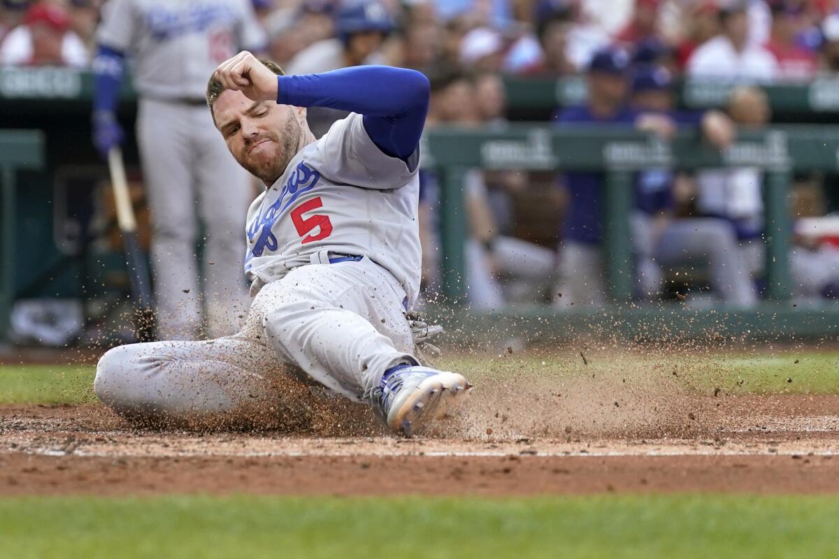 Dodgers first baseman Freddie Freeman slides into home plate to score a run.