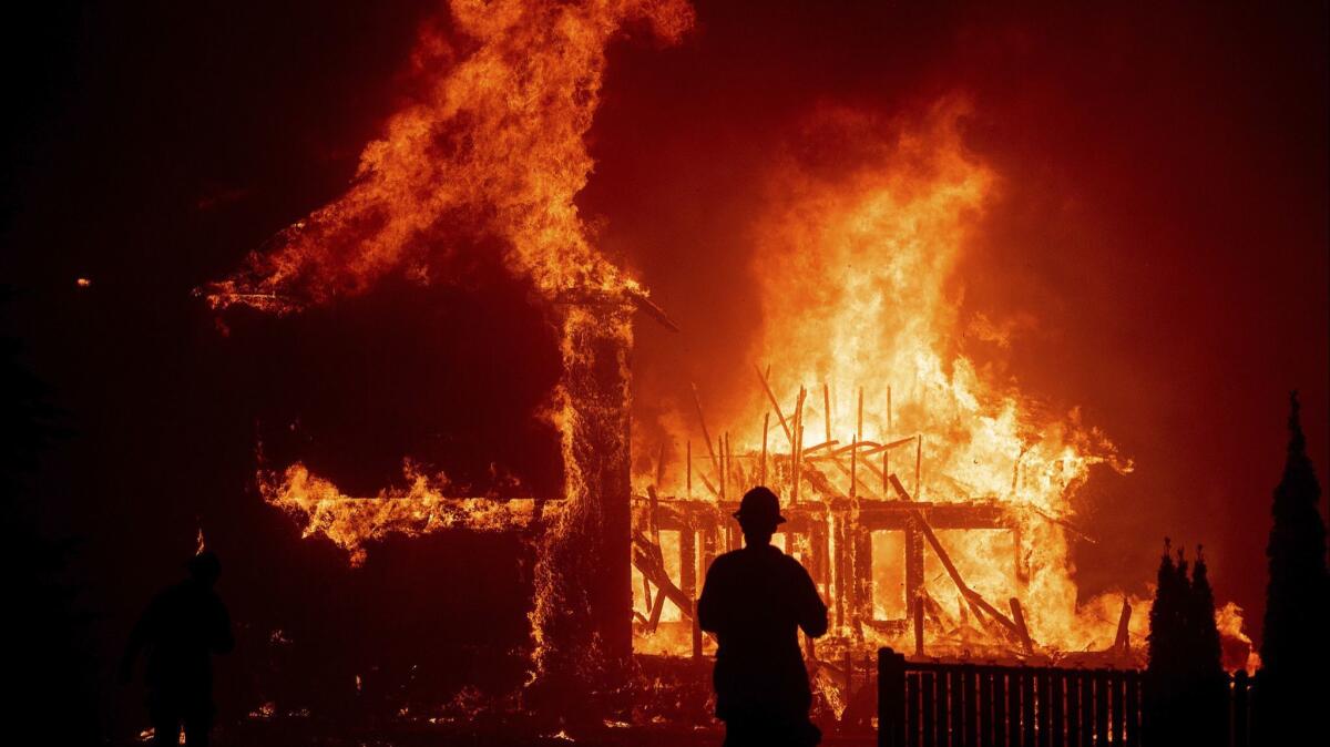 A home burns as the Camp fire rages through Paradise on Nov. 8. If investigators determine equipment owned by Pacific Gas & Electric Co. started the blaze, the costs to the utility could be substantial.