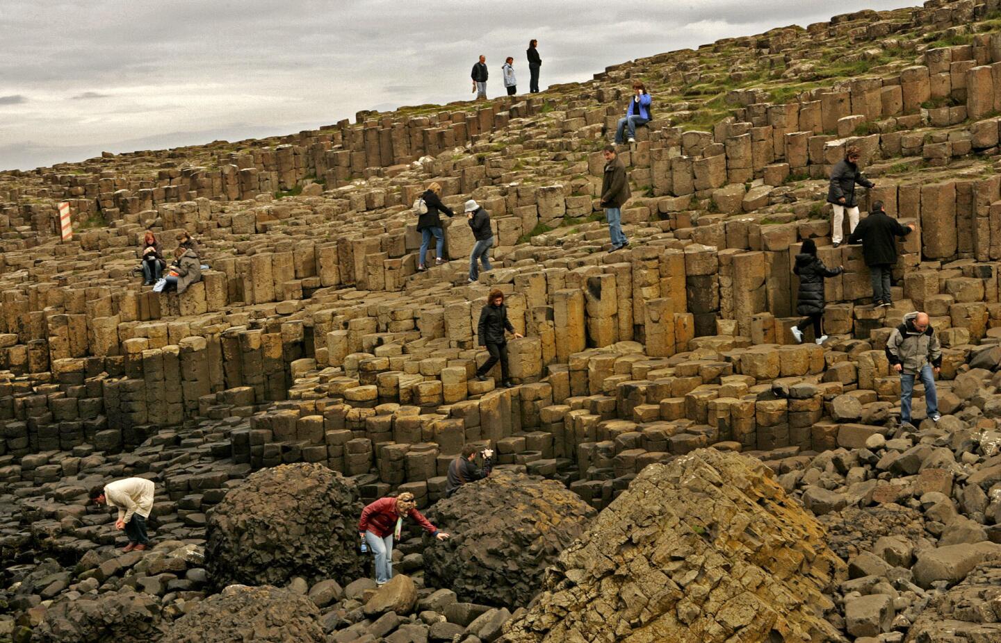 Year inscribed: 1986 Location: Northern Ireland The Giant's Causeway, at the foot of basalt cliffs in Northern Ireland, is made up of 40,000 black basalt columns jutting out of the ocean. Volcanic activity 50 million to 60 million years ago created these step-like columns on the edge of the Antrim plateau. The tops of the causeway columns form "stepping stones" that lead from the foot of the cliff and disappear under the sea. Legend has it that the mythical hunter-warrior Fionn mac Cumhaill (Finn McCool) built the causeway to aid in the fight against Benandonner, his Scottish counterpart.