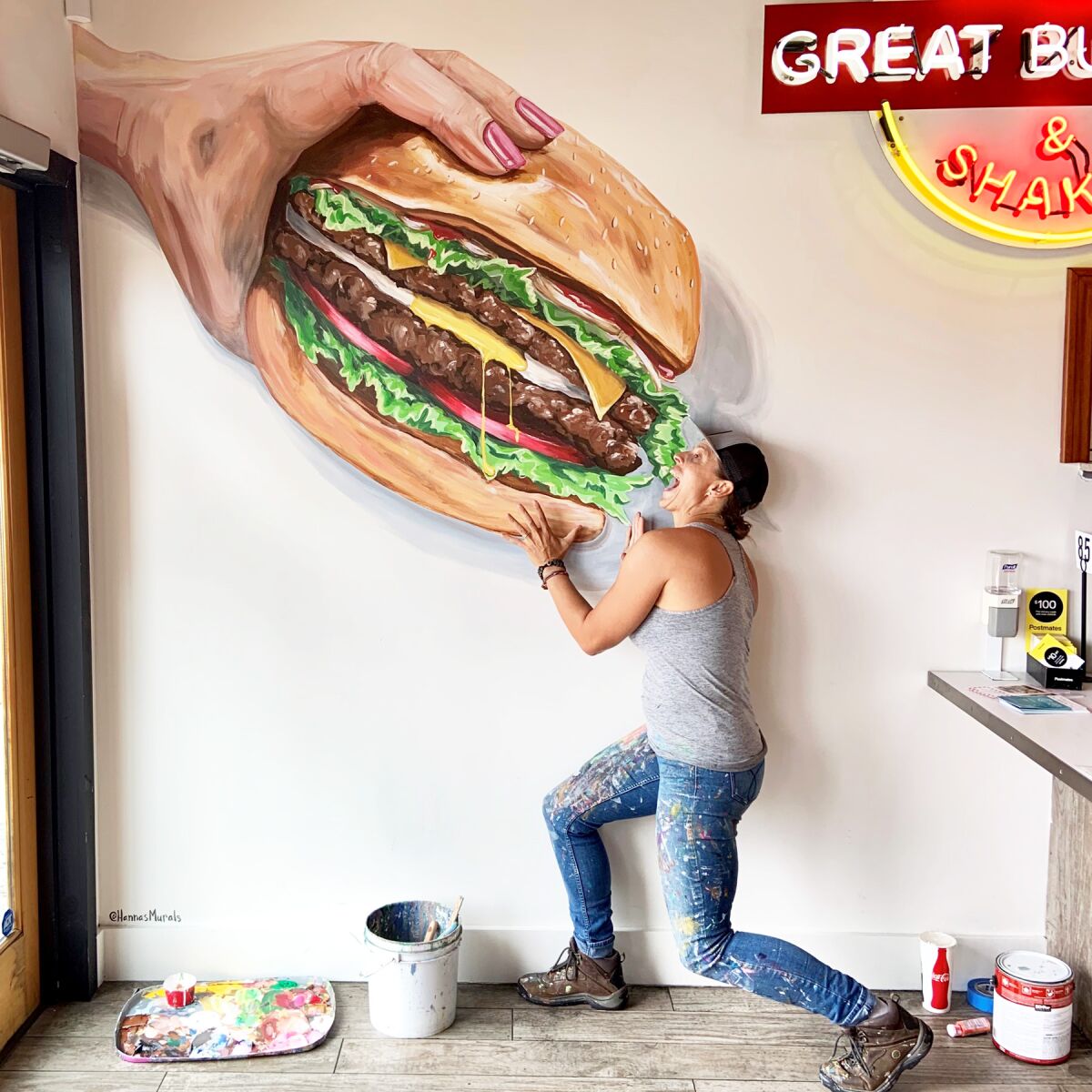 Hanna Daly with the oversized burger she painted at Biggie’s Burgers, 4631 Mission Blvd. It makes for great selfies.