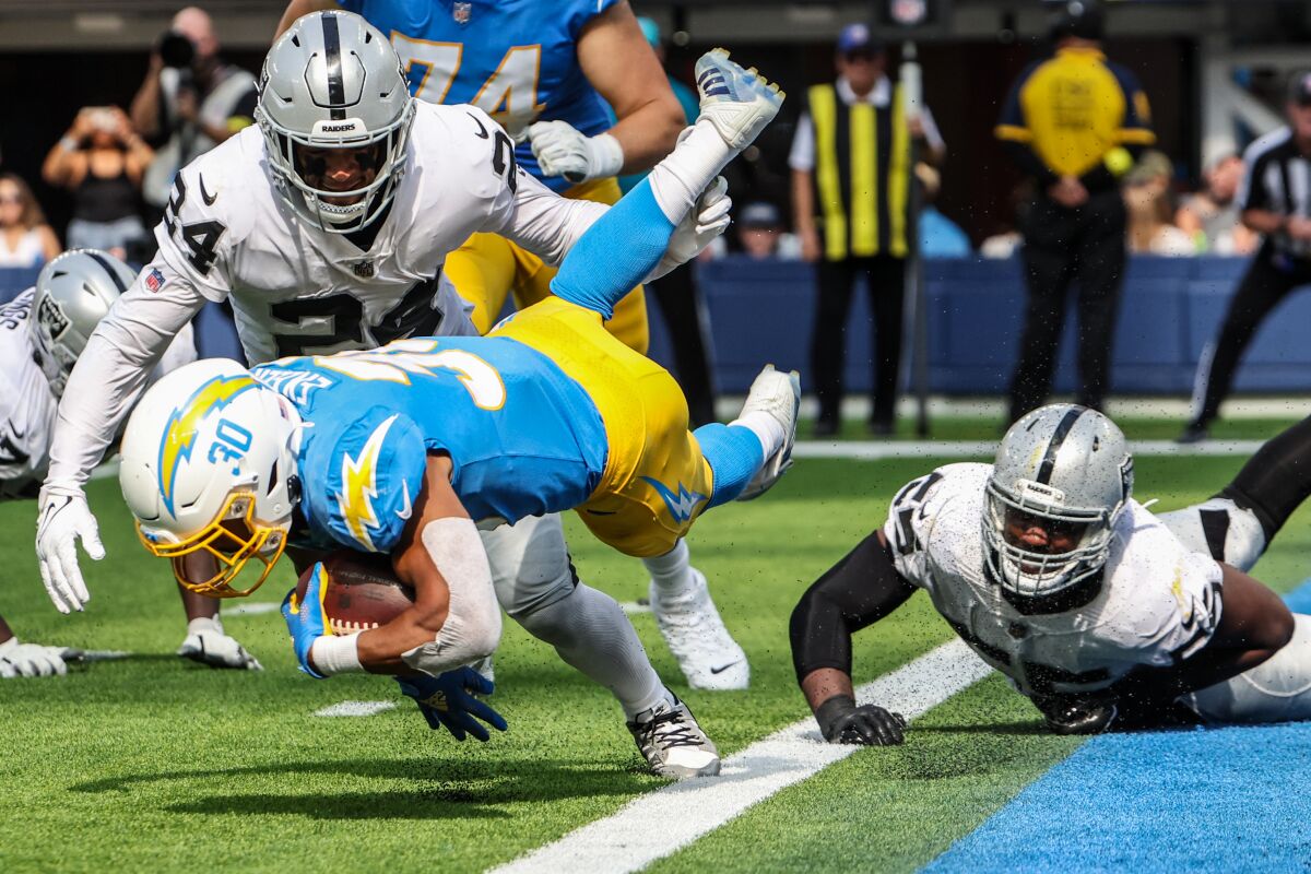 Chargers running back Austin Ekeler is tripped at the goal line by Las Vegas Raiders defensive end Chandler Jones.