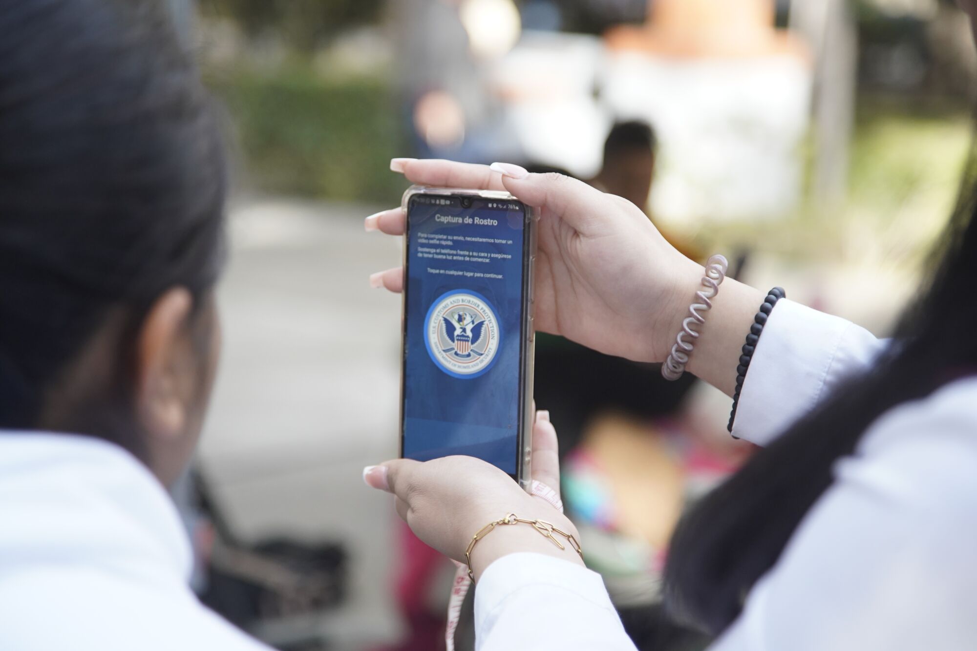 Un funcionario de Tijuana ayuda a una mujer migrante con la aplicación CBP One 