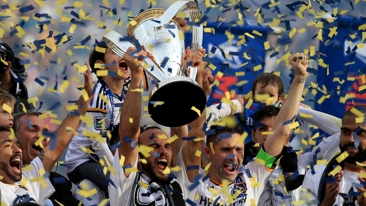 Galaxy forward Landon Donovan holds the MLS Cup trophy while celebrating the team's championship victory over the New England Revolution at StubHub Center on Dec. 7, 2014.