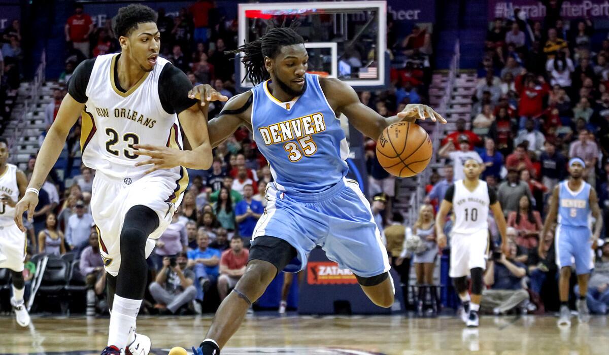 Nuggets forward Kenneth Faried gains control of the ball against Pelicans forward Anthony Davis during the Nuggets' 118-111 double overtime victory over the Pelicans on Sunday.