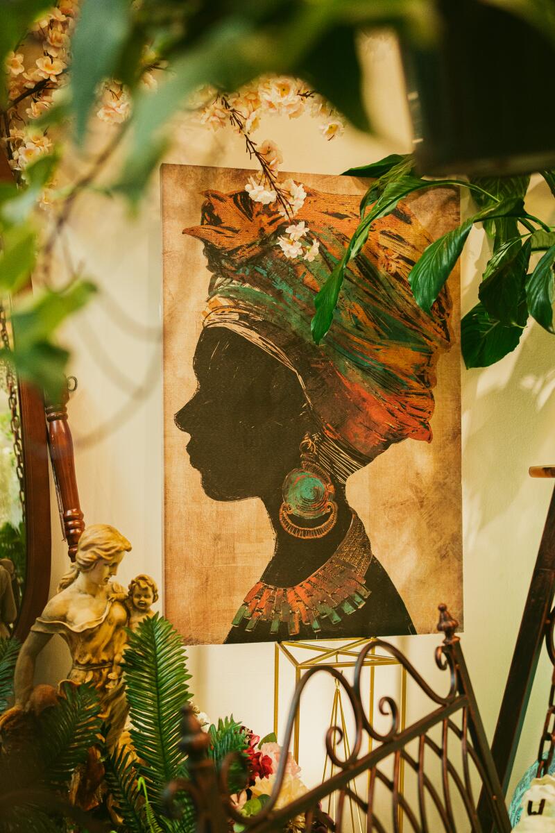A rectangular art piece of a silhouetted Black woman's head in a colorful headscarf