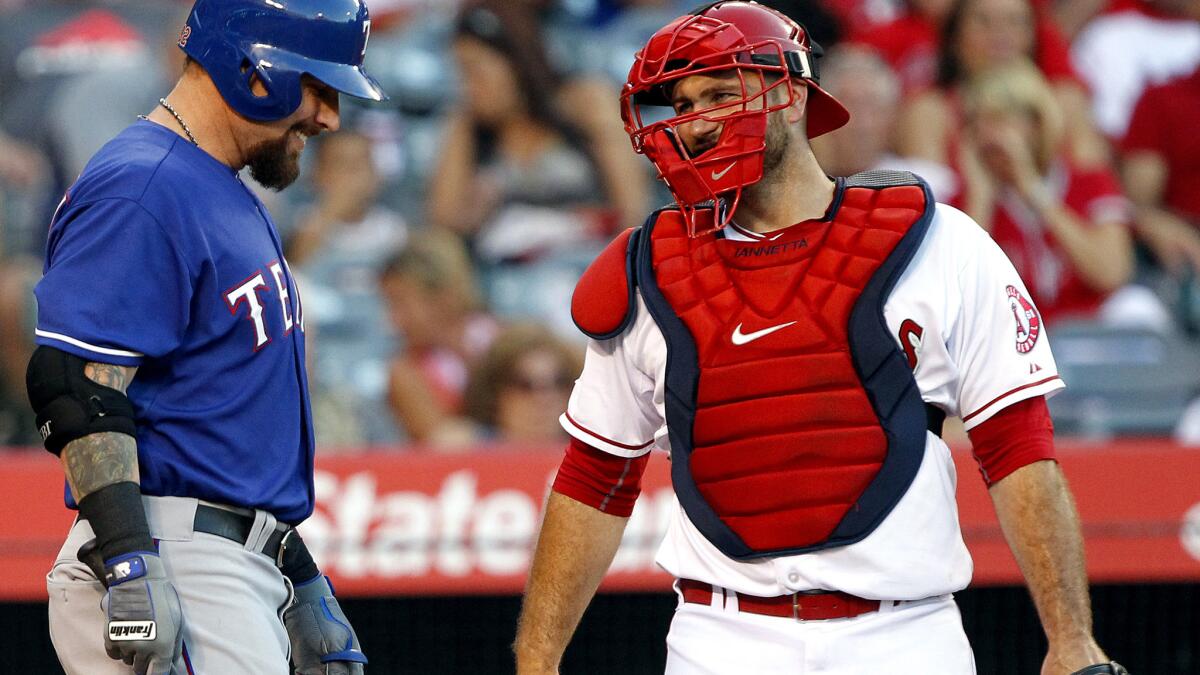 Rangers left fielder Josh Hamilton and Angels catcher Chris Iannetta react as fan boo the Texas slugger during his return to Anaheim after a trade earlier this season.